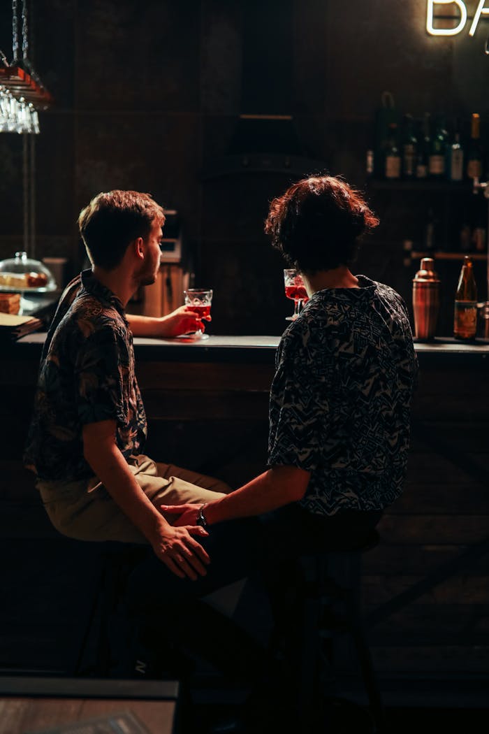 Two adults enjoying drinks at a cozy bar, reflecting a warm and intimate atmosphere.